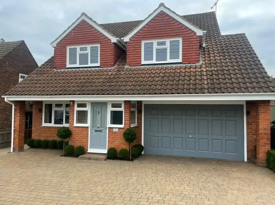 large house with grey front door and garage