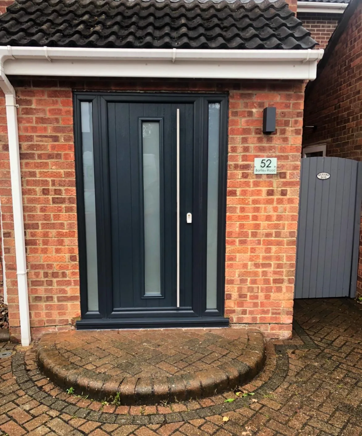 grey compsite door on front porch of house